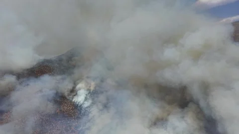 Cinematic aerial drone view from inside a thick smoke plume showing active Stock Footage 328157515