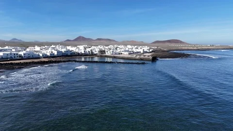 Cinematic aerial drone view of waves crashing into the harbor in Lanzarote Stock Footage 327652096