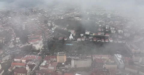 Cinematic Aerial flying through clouds and mist reveals Brasov's popular church Stock Footage 198220937