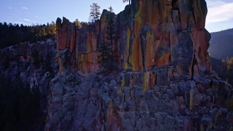 Cinematic aerial flyover of rugged cliffs with isolated trees in desert 스톡 동영상 332620813