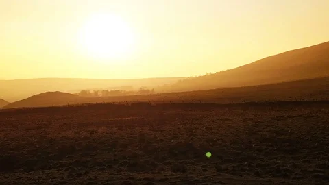 Cinematic aerial pull back reveal of sunset fields and countryside Stock Footage 105312945
