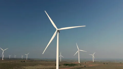 Cinematic aerial shot of wind turbines on large wind farm turning at full speed  Stock Footage