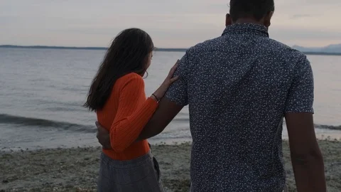 Cinematic angle of couple walking on beach Stock Footage 111976872