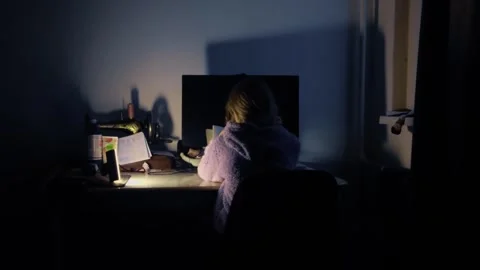 Cinematic Back View of Child Studying at Desk Under Warm Lamp Light Stock Footage 327770899