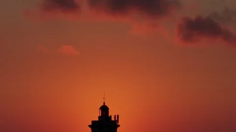 Cinematic backlit view of sunset view behind a silhouette of a lighthouse Stock Footage 315250084