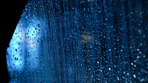 Cinematic blue evening light with raindrops on car window 库存影片 325508693
