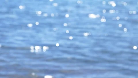 Cinematic blurry blue water surface with bright sparkling bokeh sunlight. Stock Footage 337408750