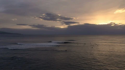 Cinematic camera circles waves and surfers revealing beautiful sunset Stock Footage 112698012