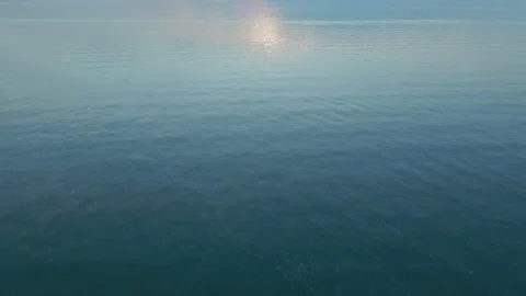 Cinematic camera flight over a large blue lake at a pink sunset Video stock 166546203