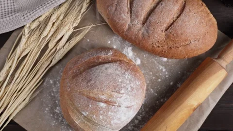 Cinematic camera movement over fresh artisan bread with wheat and baking tools Stock Footage 342485624