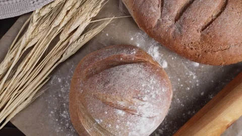 Cinematic camera movement over fresh artisan bread with wheat and baking tools Stock Footage 342485837