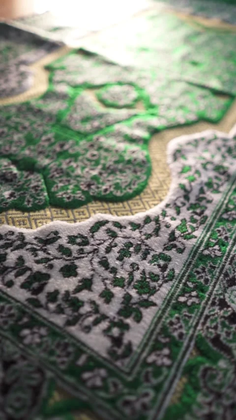 Cinematic camera movement over a green Muslim prayer rug, focusing on texture Видео 348735685