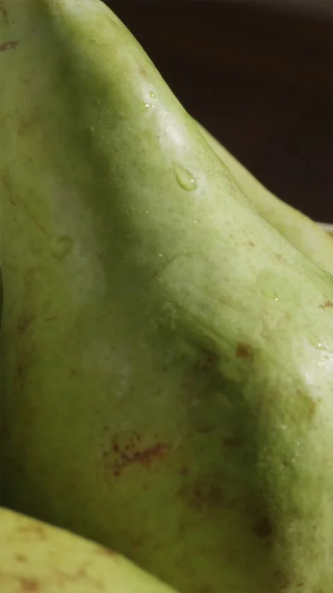 Cinematic camera pull back from fresh pear with dew drop in sunlight Stock Footage 346903352
