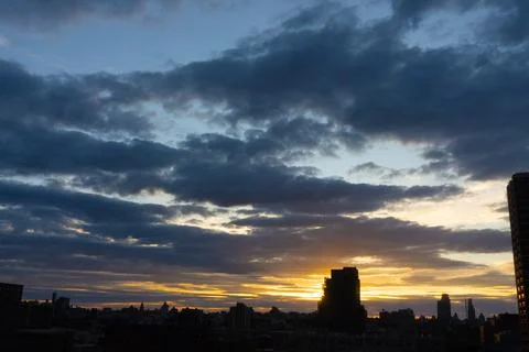 Cinematic cityscape at sunset with dramatic clouds Stock Photos