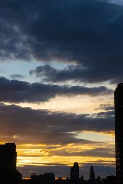 Cinematic cityscape at sunset with dramatic clouds Stock Photos