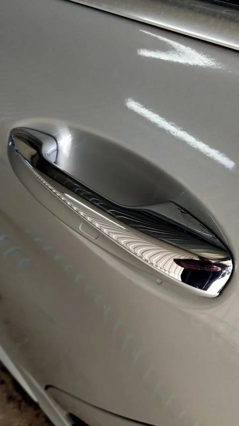 Cinematic close-up of a chrome door handle on silver car Stock Footage 334128710