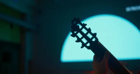 Cinematic close up classical guitar neck, light against a dark concert stage Stock Footage 327842910