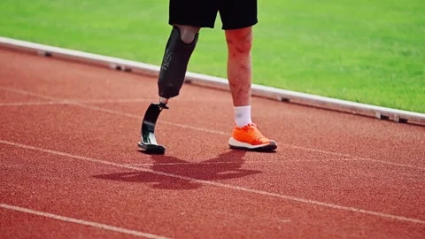 Cinematic close-up of a disabled man with a prosthetic leg on a treadmill. .. 스톡 동영상 241320554
