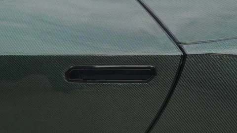 Cinematic close-up of flush door handle on carbon fiber supercar Stock Footage 335075890