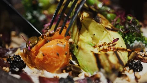 Cinematic close up of fork cutting roasted sweet potato and grilled avocado.. Stock Footage 339214915
