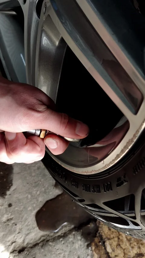 Cinematic close-up of a hand checking tire pressure on car Stock Footage 334128899