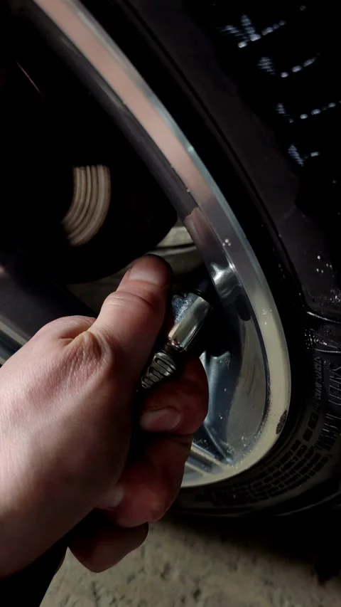 Cinematic close-up of a hand checking tire pressure on car Stock Footage 334129092