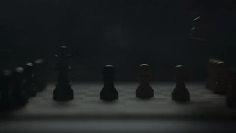 Cinematic close-up of a hand moving a chess piece in a dark atmospheric room. Vídeo Stock 333295195