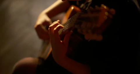 Cinematic close up of hands playing a classical guitar in warm sunset light Stock Footage 331317628