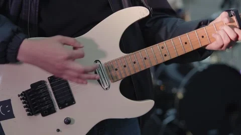 Cinematic close-up of hands playing a white electric guitar Stock Footage 335076100