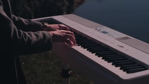 Cinematic Close-Up of Hands Playing White Digital Piano Outdoors Stock Footage 335103632