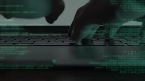 A cinematic close-up of hands typing on a keyboard with layered code Stock Footage 334175495