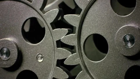 A cinematic close-up of interlocking metal cogs and gears rotating slowly Stock-Footage 337223406