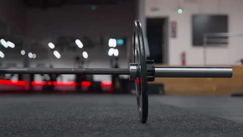 Cinematic Close-Up of Loaded Barbell Resting on Gym Floor Stock Footage 346789867