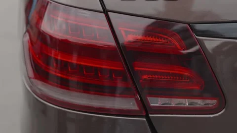 Cinematic close-up of modern car LED tail lights glowing red Stock Footage 335076169