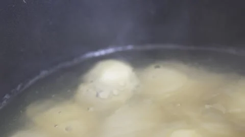 Cinematic close-up of potatoes boiling in bubbling water with steam Stock Footage 333973595