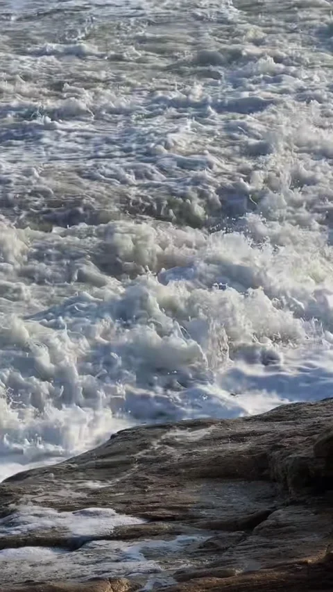 Cinematic Close-up of Powerful Ocean Waves Crashing Against Rocks Stock Footage 329143334