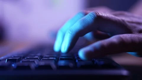 Cinematic Close-up of Programmer Hands Typing on Keyboard in Neon Light Stockbeeldmateriaal 337736775
