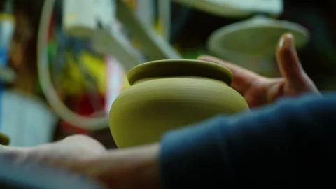 Cinematic close-up of a raw clay pot spinning on a potter's wheel Stock Footage 328925324