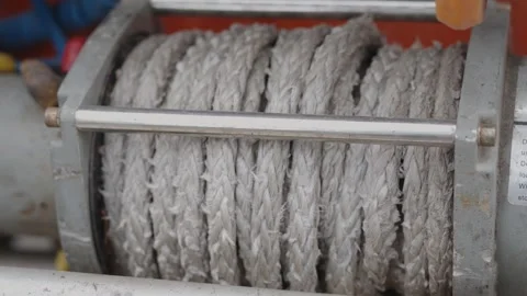 Cinematic close-up of a rugged off-road winch pulling synthetic rope Stock Footage 335075793