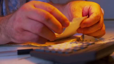 Cinematic close-up shot of writing down expense numbers from bills Stock Footage 336977543