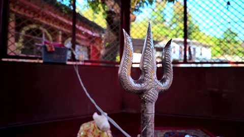 Cinematic Close Up of a Silver Trishul Trident Inside a Hindu Temple Stock Footage 329798221