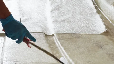 Cinematic Close-Up of Worker Using Roller Tool on Fiberglass in Boat Hull Stock Footage 323180348