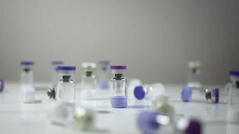 Cinematic counter-clockwise orbit around a pharmaceutical vial surrounded by Vidéo 336493022