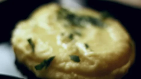 Cinematic creamy mashed potatoes served from a rustic clay pot in soft focus, 4K Stock Footage 341103779