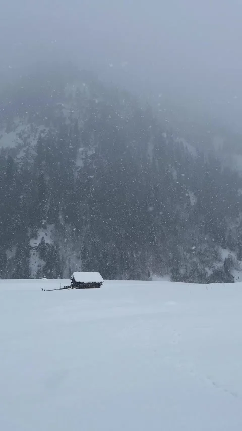 Cinematic Distant View of Log House covered by clouds in heavy snow Stock Footage 327690289
