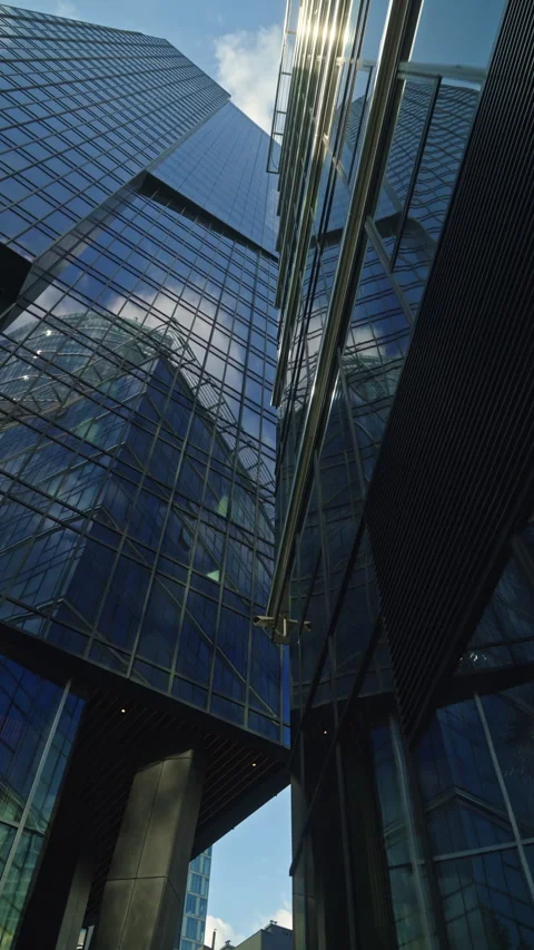 Cinematic dolly movement between modern glass skyscrapers in business district Stock Footage 335731684