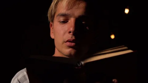 Cinematic dramatic lighting, a guy reads a book carefully, autumn day, closeup Stock Footage 119712052