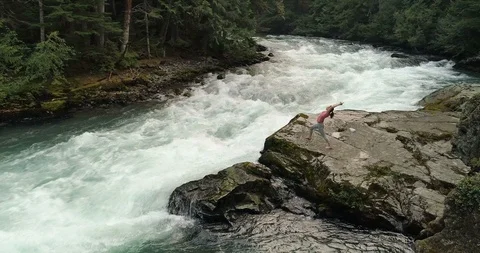 Cinematic Drone Angle Of Woman Doing Yoga By A River In The Rainforest Stock Footage 101110429
