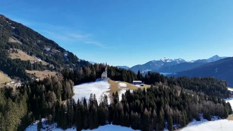 Cinematic Drone Approach to Remote Alpine Chapel on Snowy Mountain Peak Stock Footage 331597664