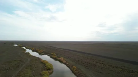 Cinematic drone ascent above winding river in Kazakhstan Stock Footage 334325880